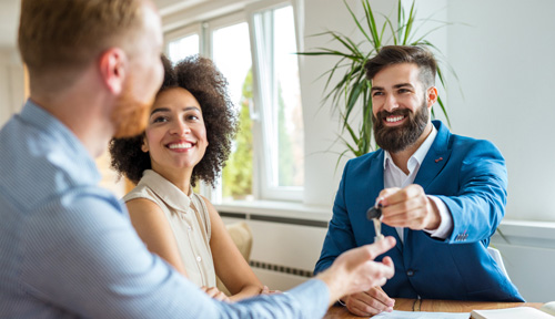 young couple receiving house keys from lender