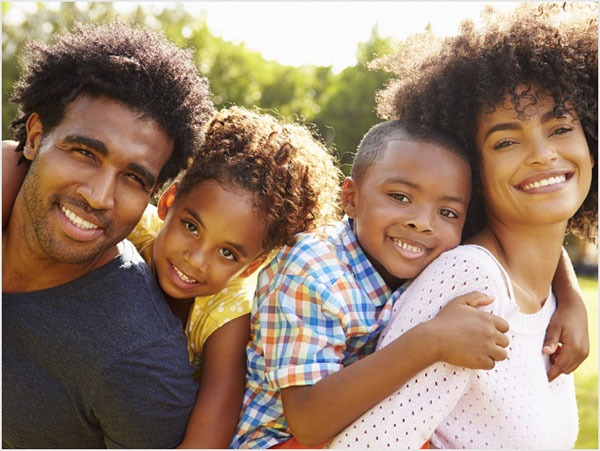 Happy family with young son and daughter posing outside