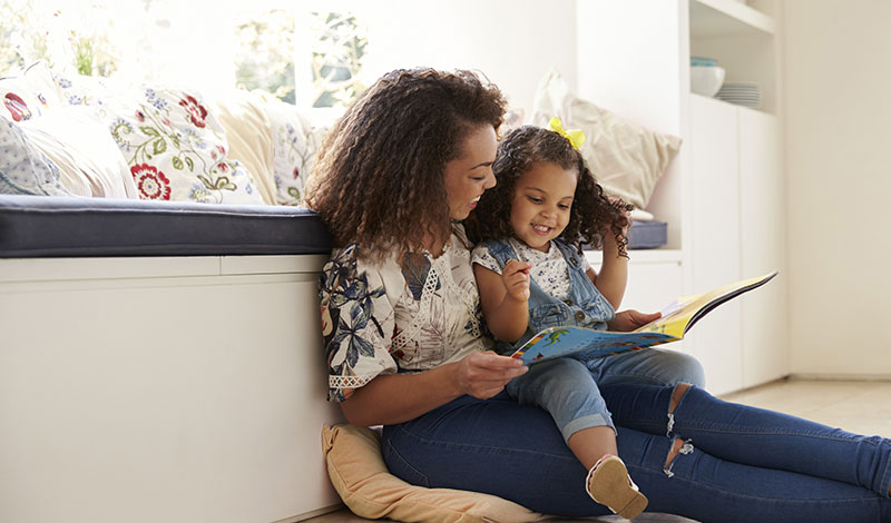 Mother reading book to daughter