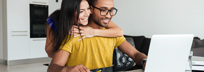 Happy couple working on laptop