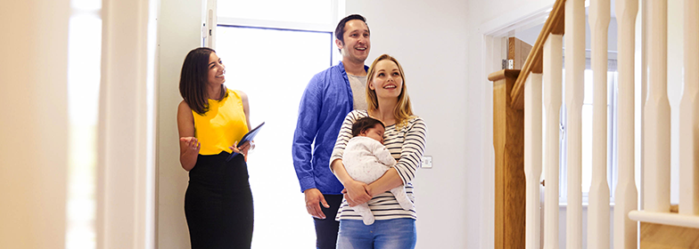 Young couple viewing home with realtor