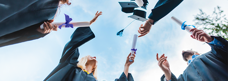 Group of students throwing graduation caps in the air