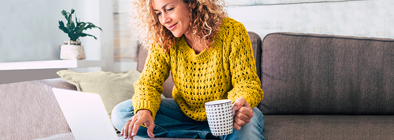 Woman sitting down looking at her laptop.