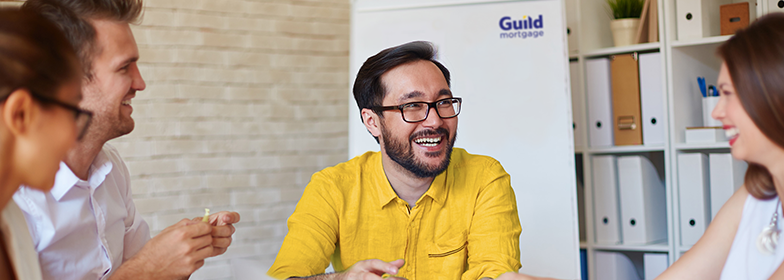 Smiling man in meeting with coworkers