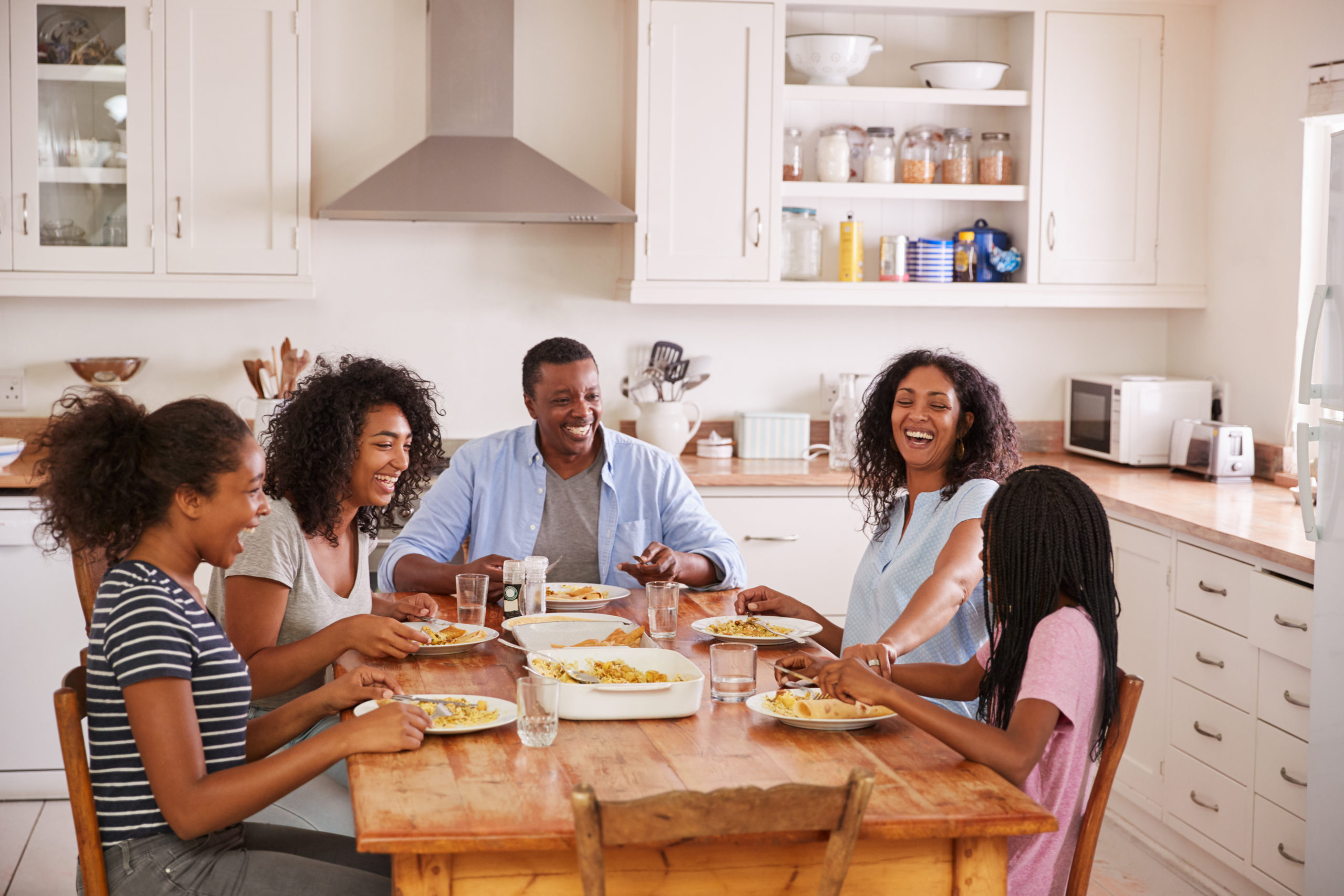 A family smiling at the dinner table.