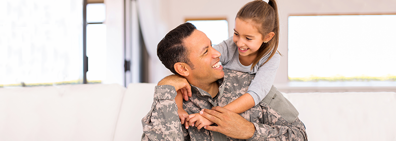 Daughter hugging Military father