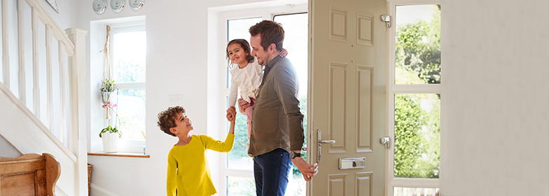 A father greeted at the front door by his two kids