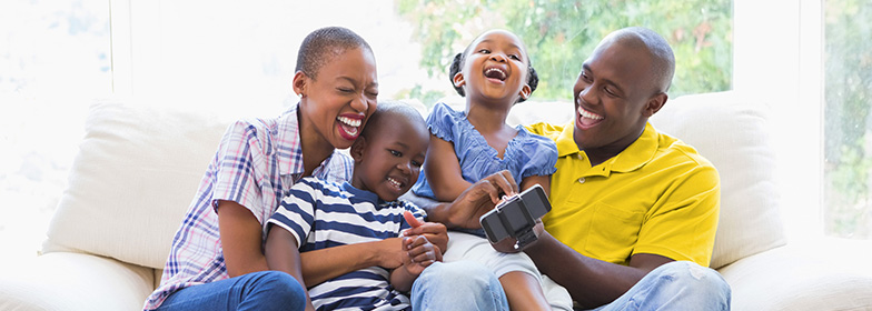 A laughing family sitting on a couch