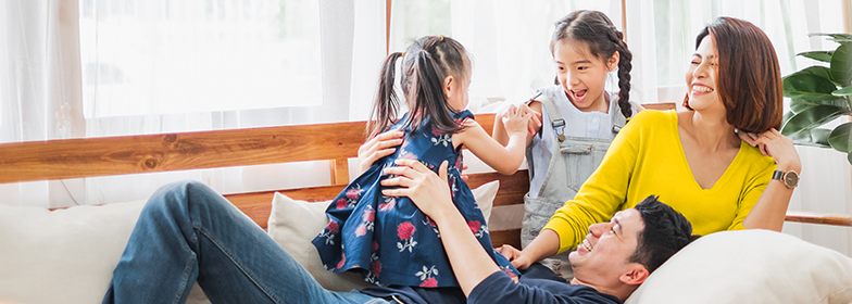 A young family playing on the couch