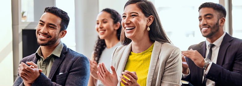 Smiling coworkers clapping at event