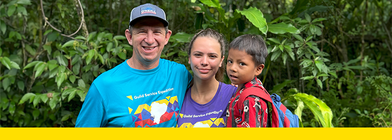 Guild Mortgage Volunteers with boy from a local village