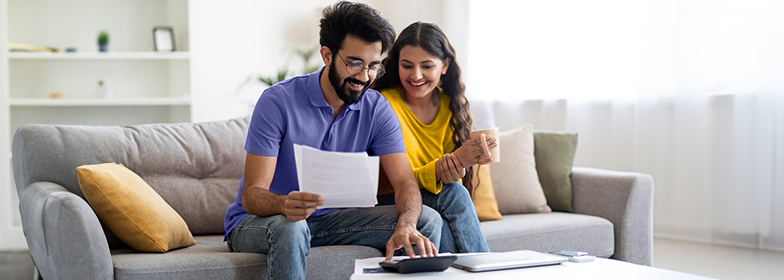 Couple looking at papers on couch